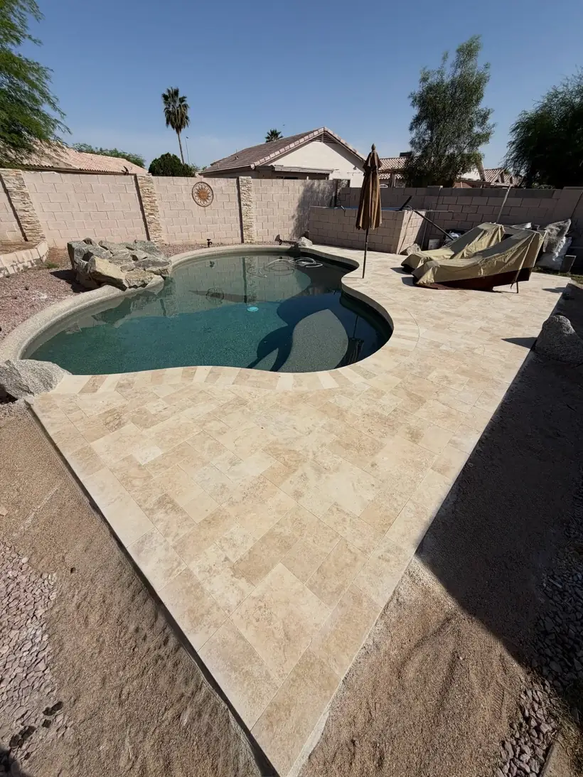 Pool with travertine deck and loungers