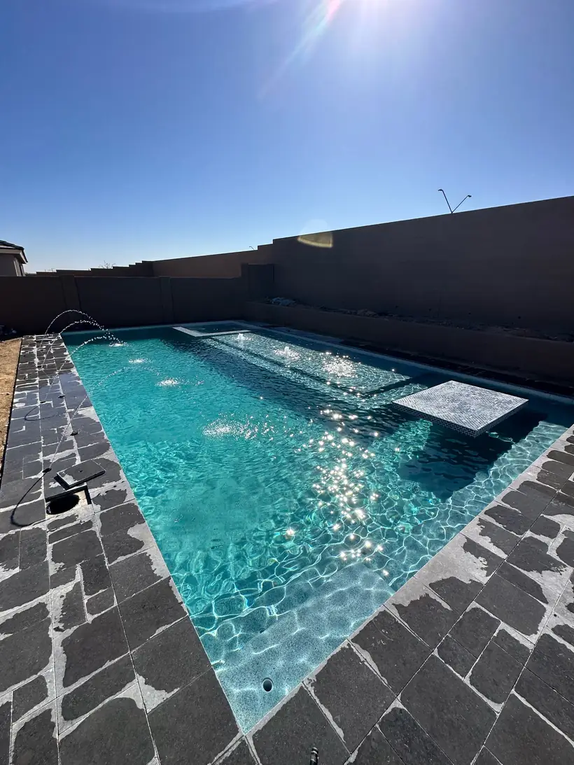 Pool with dark paver decking